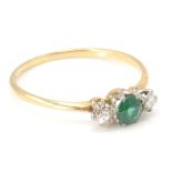 An 18ct gold diamond and green stone - 3 stone ring. The ring set with a central round mixed cut