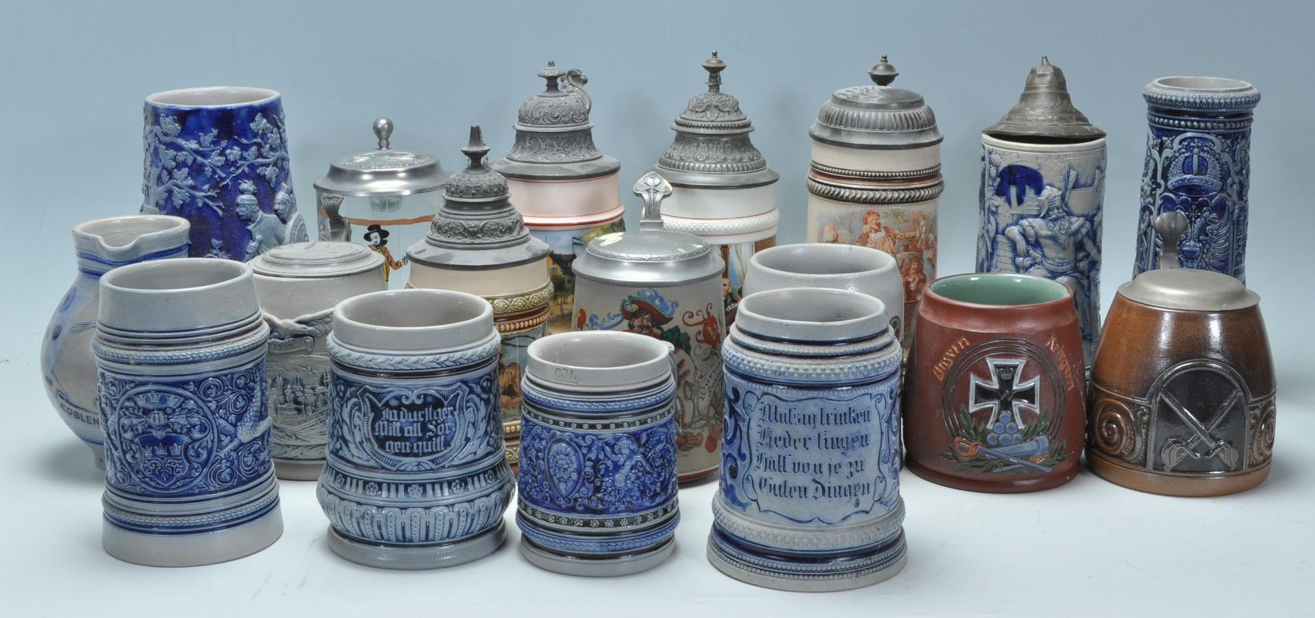 A collection of 20th Century German ceramic stein drinking glasses, many having raised blue and grey