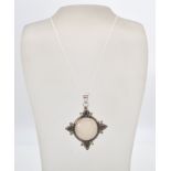 A stamped sterling silver pendant necklace with a large moonstone flanked by tourmaline and