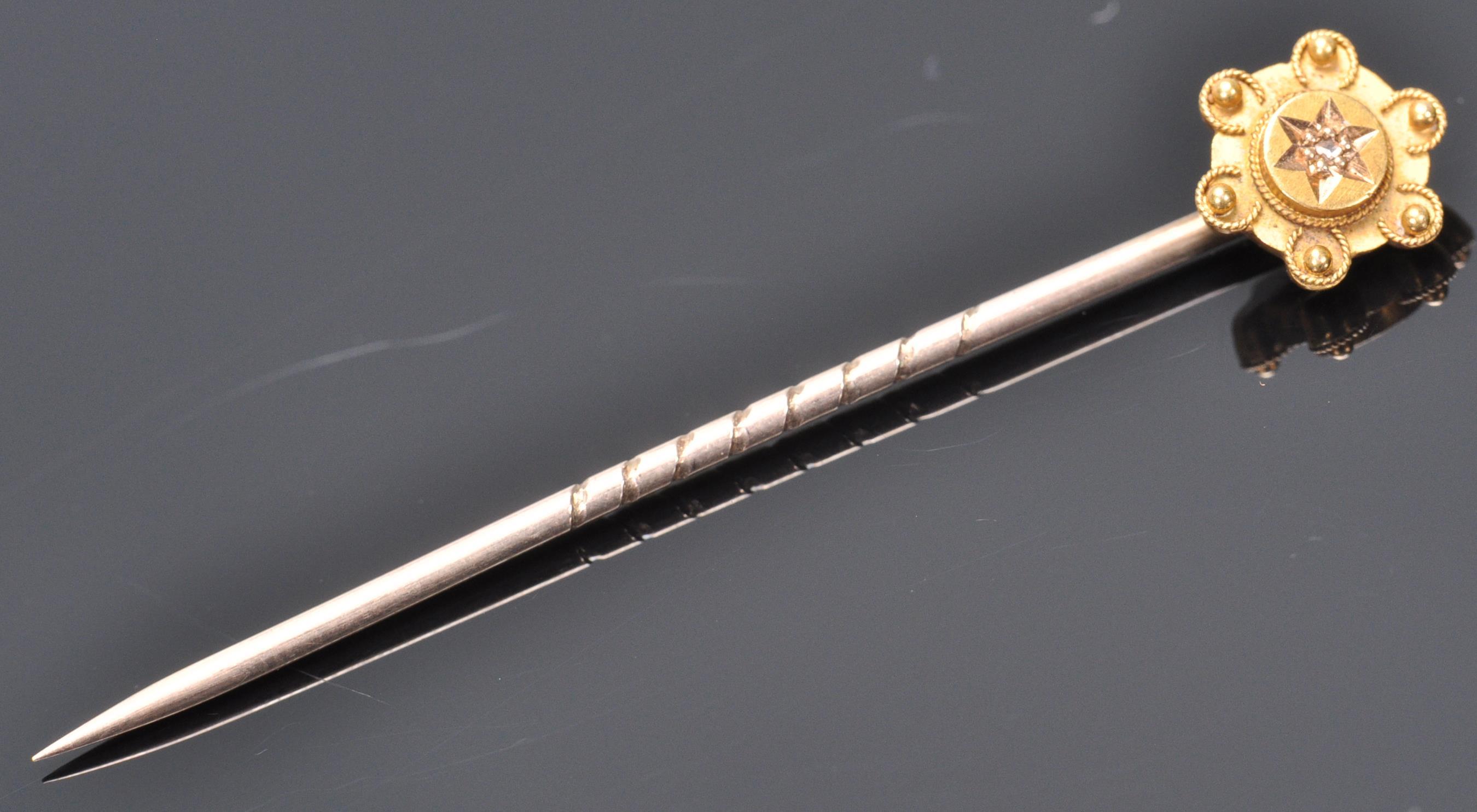 A 9ct gold toped tie pin having wire work and ball finial decoration set with a single diamond chip.