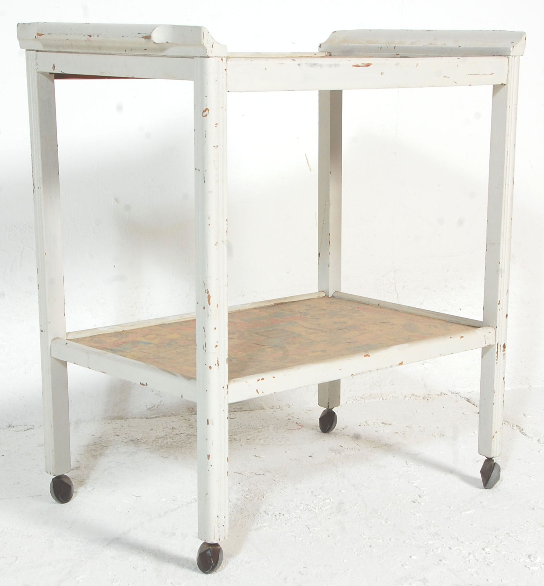 An early 20th century century shabby chic painted two tier trolley with decoupage decoration