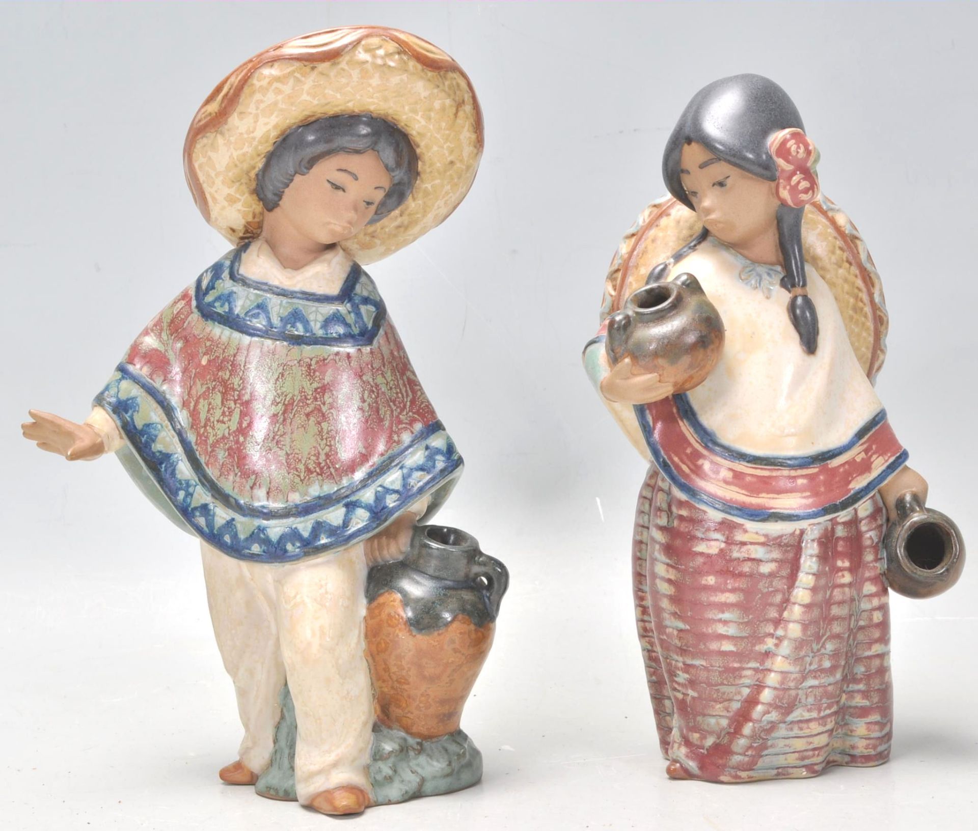 A pair of Lladro ceramic figurines in the form of a Mexican boy wearing a Sombrero and a poncho