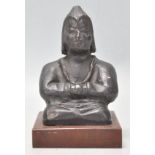 An usual Eastern clay / terracotta figure of Buddha seated crossed legged raied on a wooden plinth