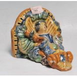 A 20th Century continental faience ceramic wall mounted shelf / sconce having a semicircular shelf