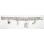 A sterling silver dual link charm bracelet having box clasp. Adorned with four charms to include a