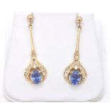 A pair of yellow gold, cornflower blue sapphire and diamond drop earrings.