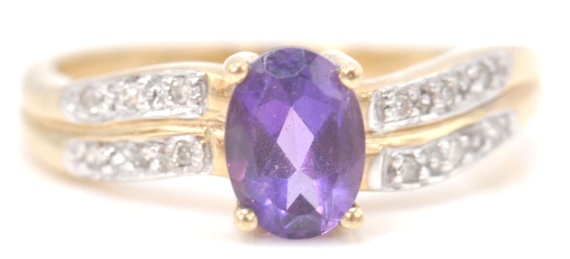 A 9ct gold hallmarked amethyst and white stone ring. The oval mixed cut amethyst with white stones
