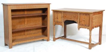 An early 20th century Jacobean revival carved oak open window  bookcase and matching writing table