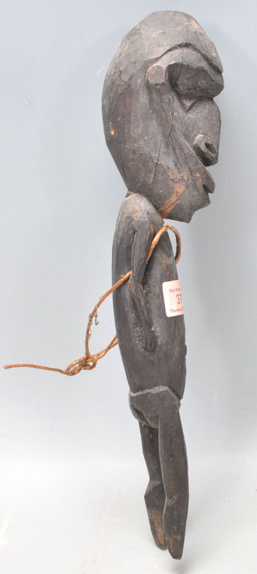 A carved tribal ebonised wooden figurine having an stylistically large head with short limbs - Bild 9 aus 9