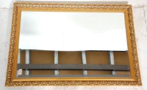 A 20th century antique revival good quality gilt framed and beveled edge overmantel mirror. The