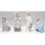 A group of four Nao porcelain figurines to include a seated girl with a perched bird, a girl in a