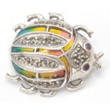 A silver and plique a jour art nouveau style brooch in the form of a ladybird with eyes set with red
