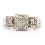 A 9ct white gold and diamond Art Deco cluster ring. The ring with pave set diamonds in prong mounts.