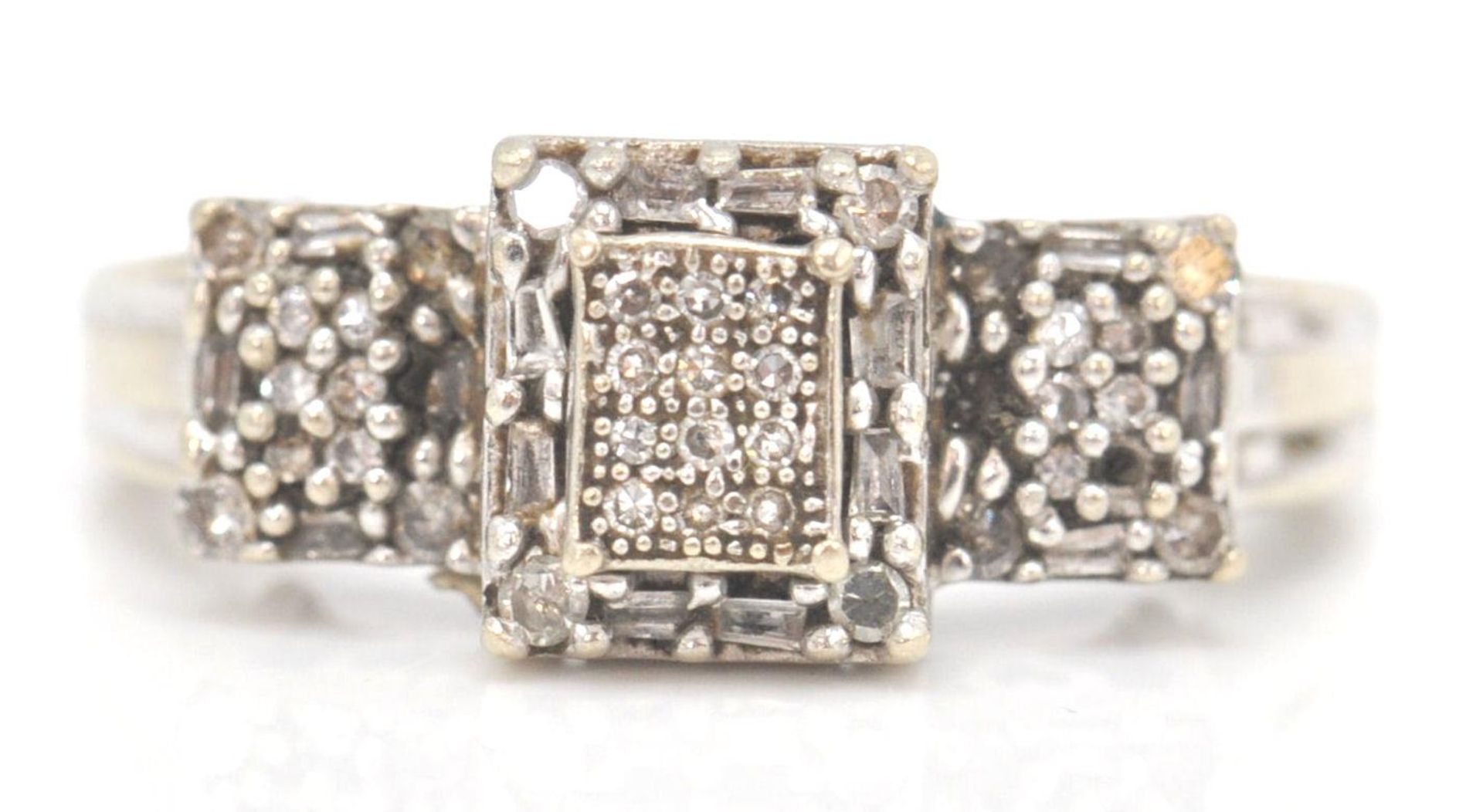 A 9ct white gold and diamond Art Deco cluster ring. The ring with pave set diamonds in prong mounts.