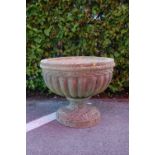 An early 20th Century reconstituted stone garden planter having a large gadrooned bowl raised on