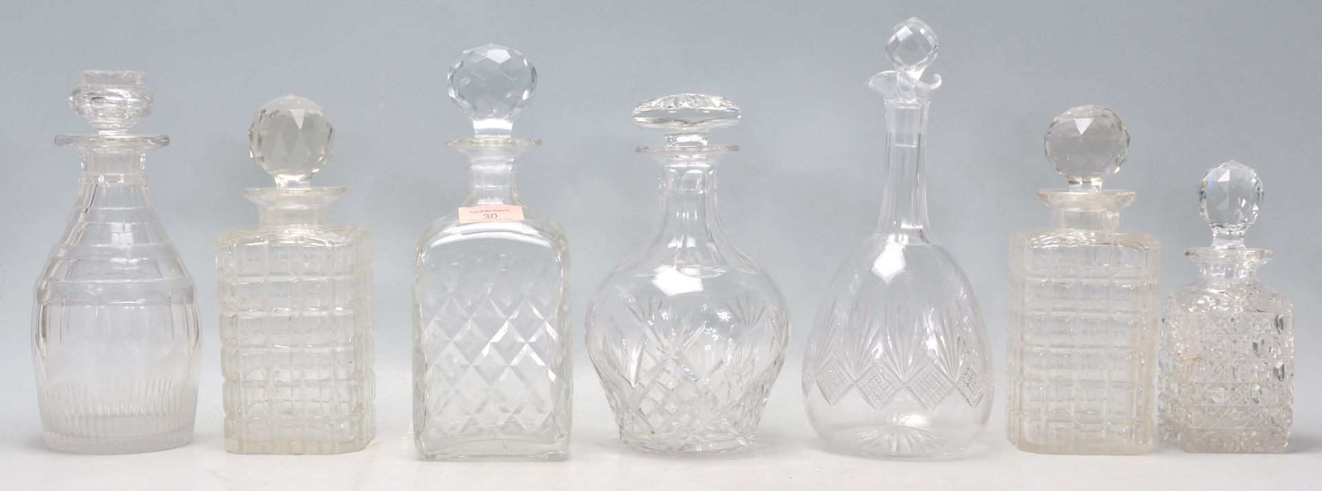 A group of seven vintage and antique cut glass decanters to include a pair of whiskey decanters with