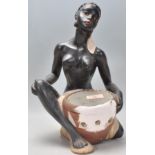 A vintage early 20th century Art Deco chalk 1920s ware figurine in the form of a seated African