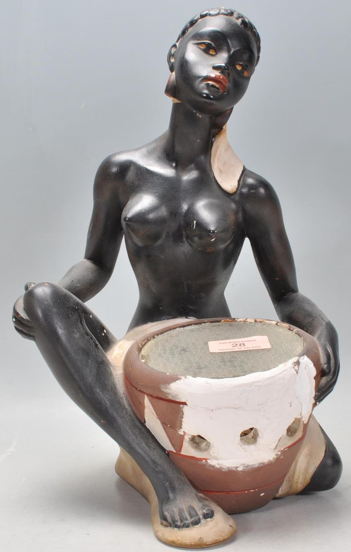 A vintage early 20th century Art Deco chalk 1920s ware figurine in the form of a seated African