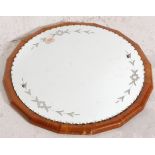 A mid 20th Century walnut veneered mirror of circular form having an applied mirror plate with