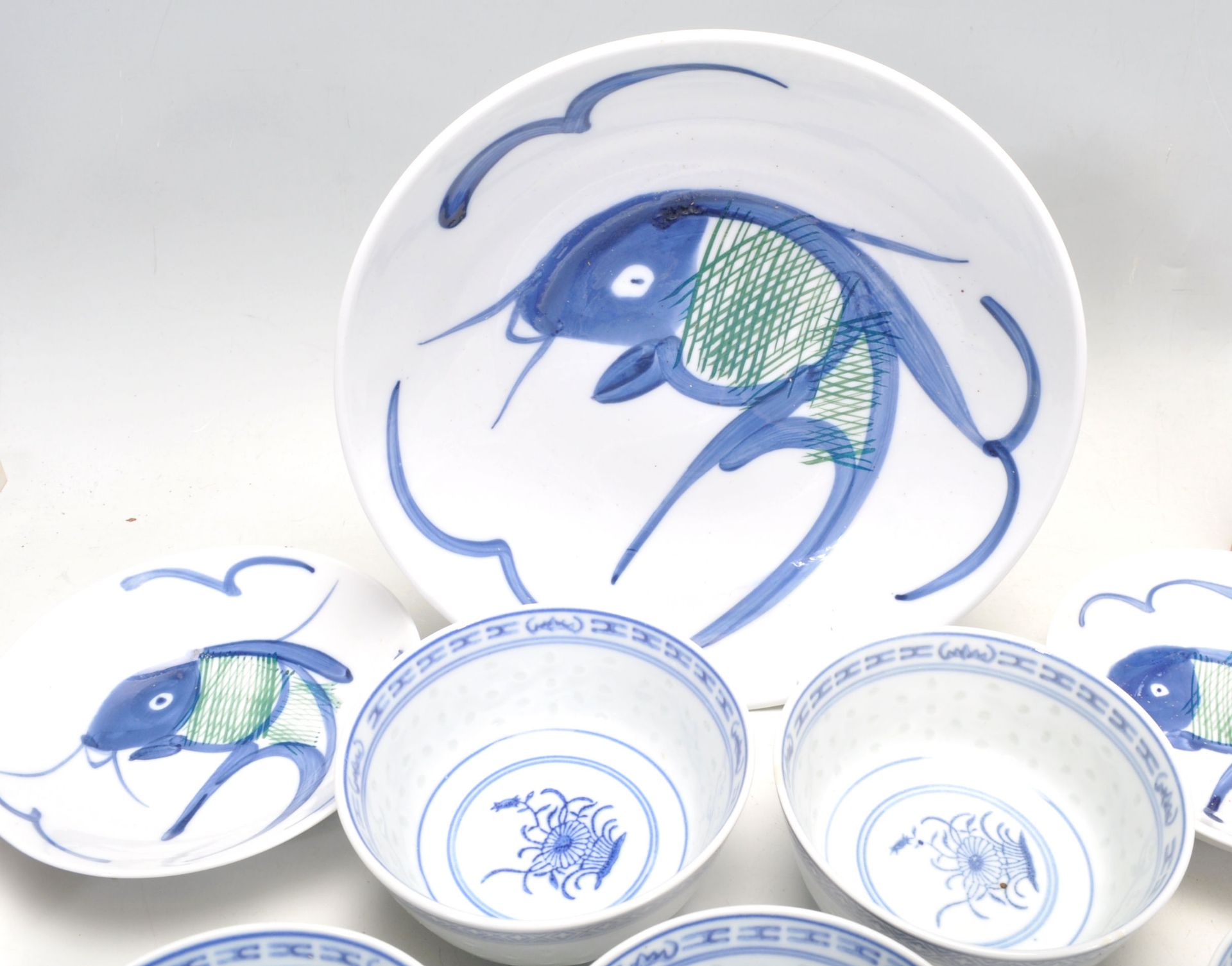 A collection of 20th Century Chinese / Japanese blue and white rice bowls with floral and plantain - Bild 2 aus 12