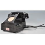 A vintage early 20th Century bakelite rotary dial telephone finished in black having a winding crank