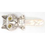 A stamped sterling silver childs rattle in the form of a Louis Wain style cat with yellow glass eyes