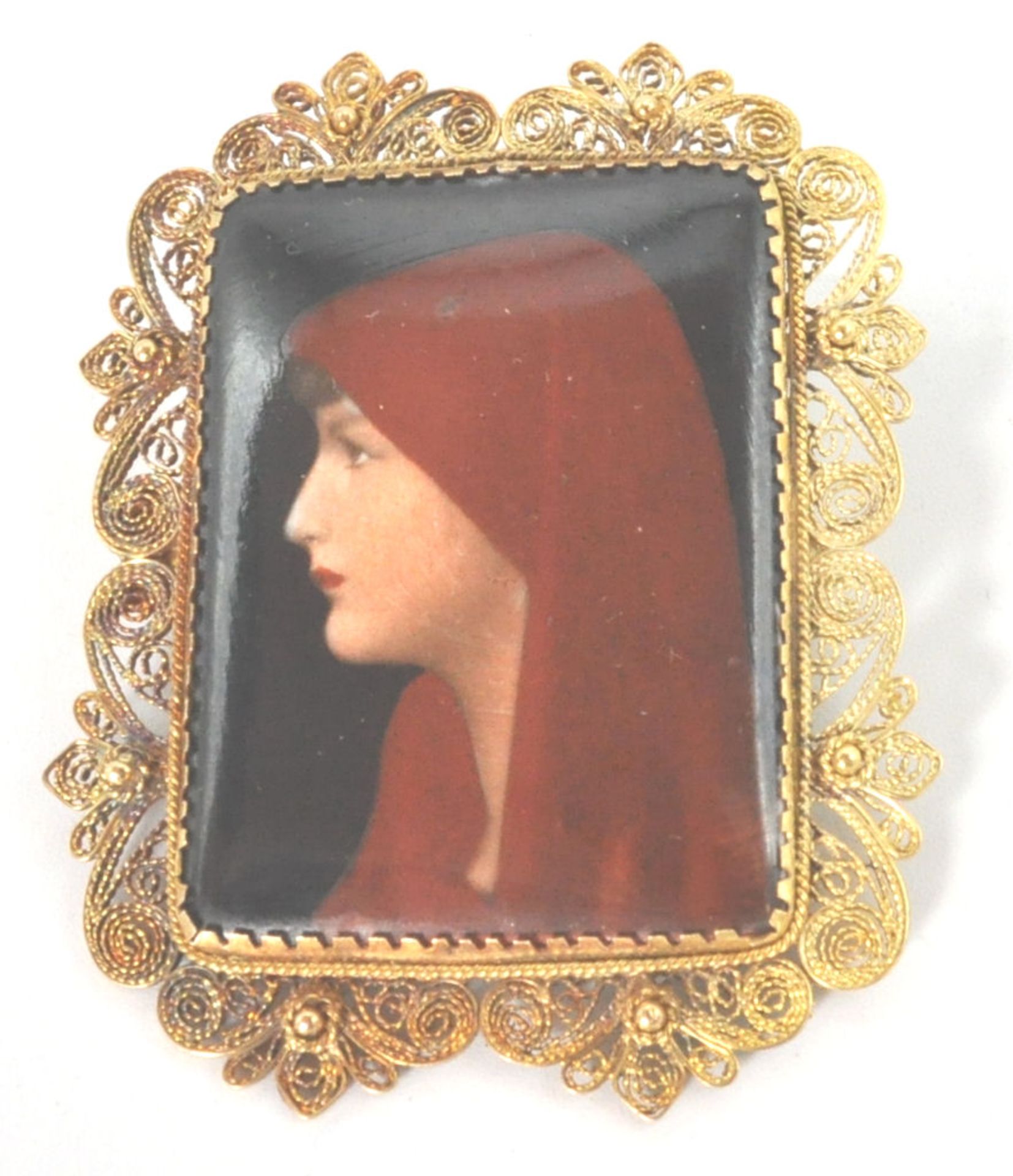 A 19th Victorian hand painted miniature of a hooded lady in the form of a brooch edged with filigree