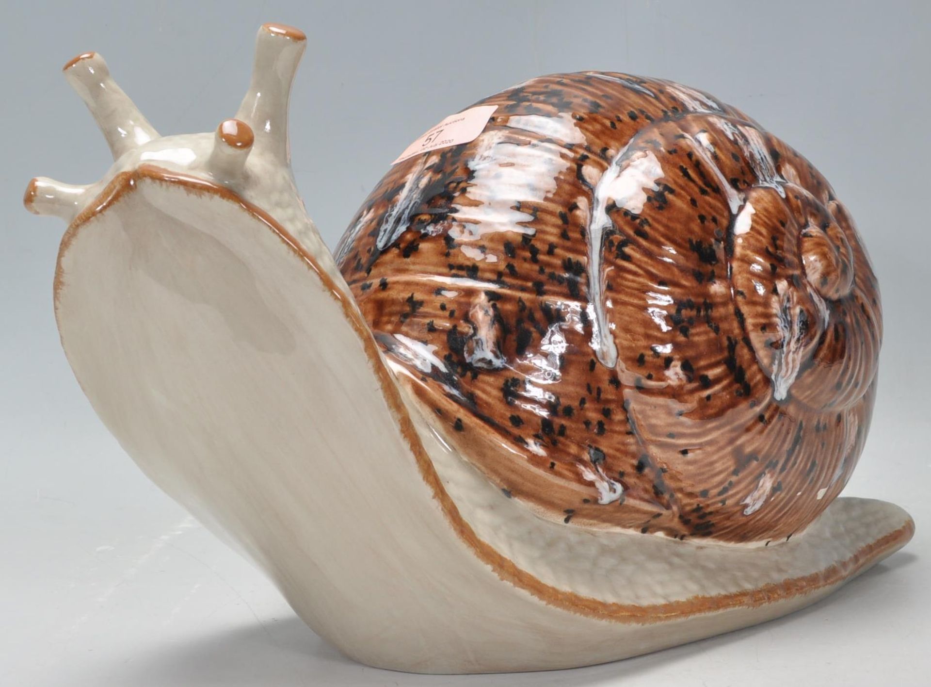 A vintage late 20th Century studio art pottery figurine in the form of a snail having a mottled
