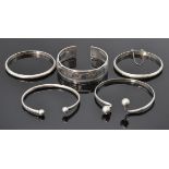 A good group of five silver bangle bracelets to include a Egyptian bangle having engraved panels