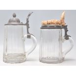 A pair of 19th century German glass steins of heavy facet cut glass design, one with stag antler
