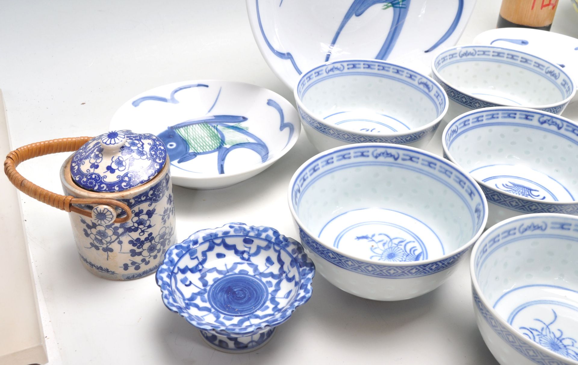 A collection of 20th Century Chinese / Japanese blue and white rice bowls with floral and plantain - Bild 5 aus 12