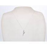 A 9ct white gold necklace chain and pendant. The white gold pendant of scroll form set with