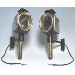 A pair of 19th Century Victorian coaching lamps having black ebonised bodies with brass oval