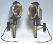 A pair of 19th Century Victorian coaching lamps having black ebonised bodies with brass oval