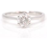 An 18 ct white gold single stone diamond ring. The cushion-shaped diamond, claw-set to a polished