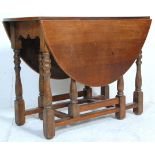 An early 20th Century country oak gate leg table raised on on block and turned legs suporting an