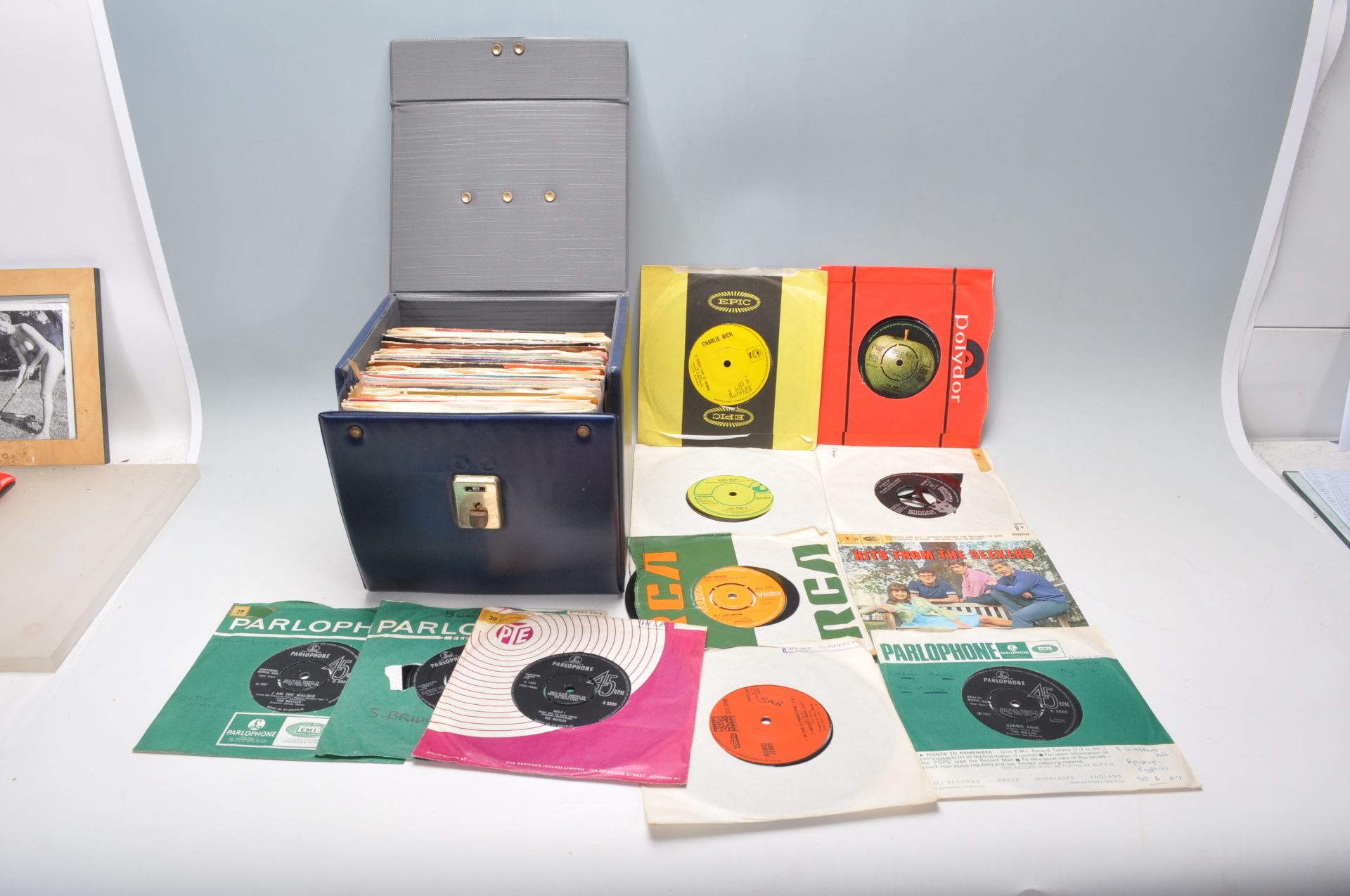 A case full of 45rpm vinyl 7" singles of varying artists and genres to include multiple Beatles