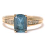 A stamped 375 9ct gold ladies dress ring set with a rectangular cut blue stone with three accent