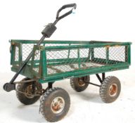 A metal four wheel pull along trolley finished in