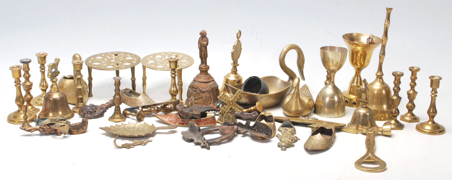 A good collection of miniature brass candlestick, brass trivets with pierced top, brass table bells,