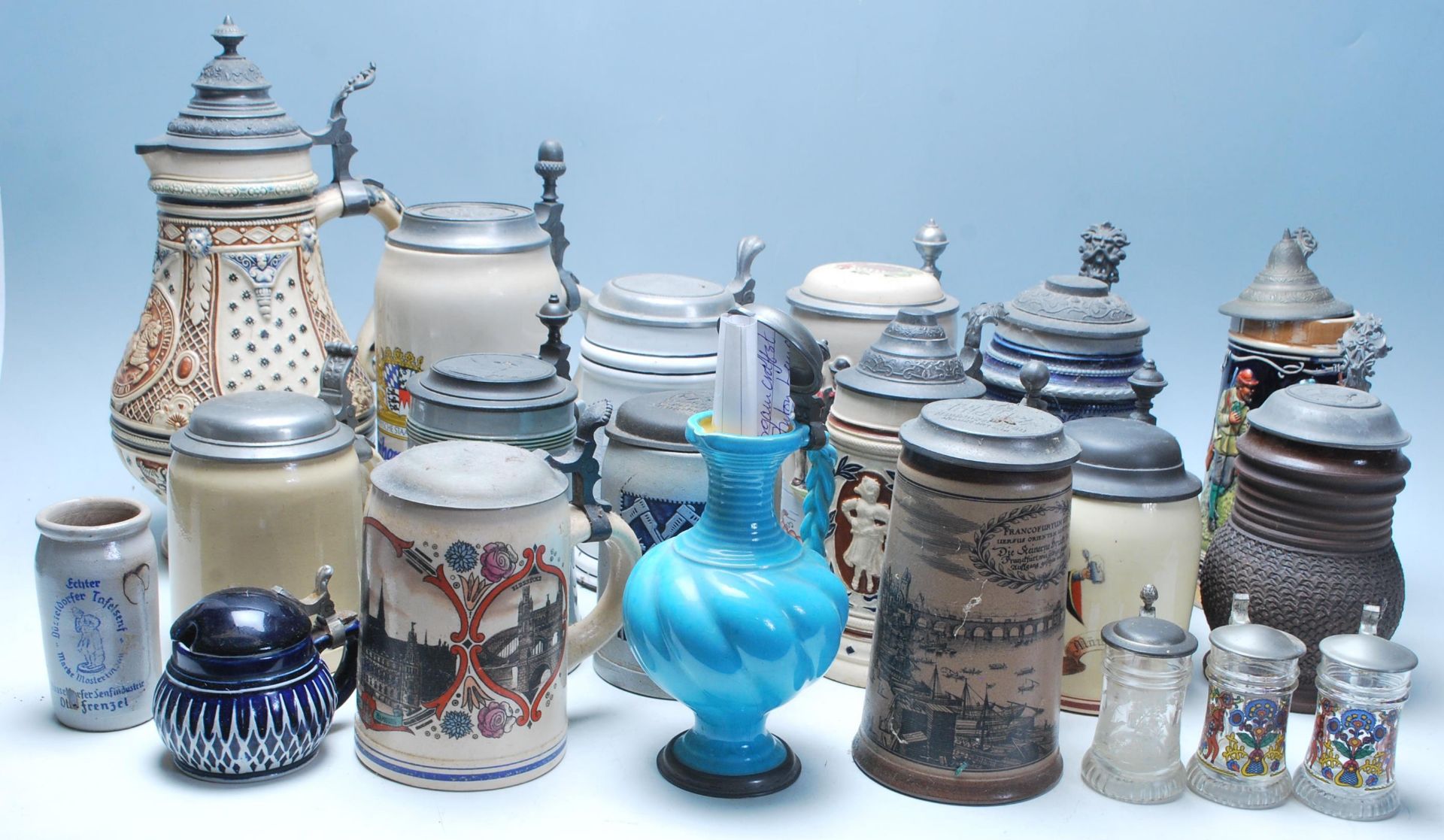 A large collection of German blue and grey stoneware jugs and beer steins, some having pewter