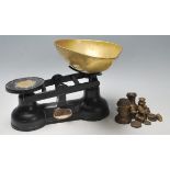 A set of antique ' The Salter ' balance scales, having an ebonised cast iron base with brass tray