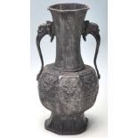 A Chinese antique cast metal gu shaped vase of panelled form, the body having repeating panels