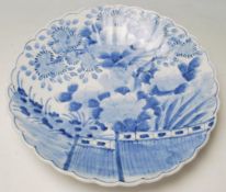 A late 19th / early 20th Century Meji period Japanese blue and white plate having a scalloped rim