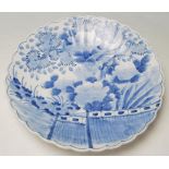 A late 19th / early 20th Century Meji period Japanese blue and white plate having a scalloped rim