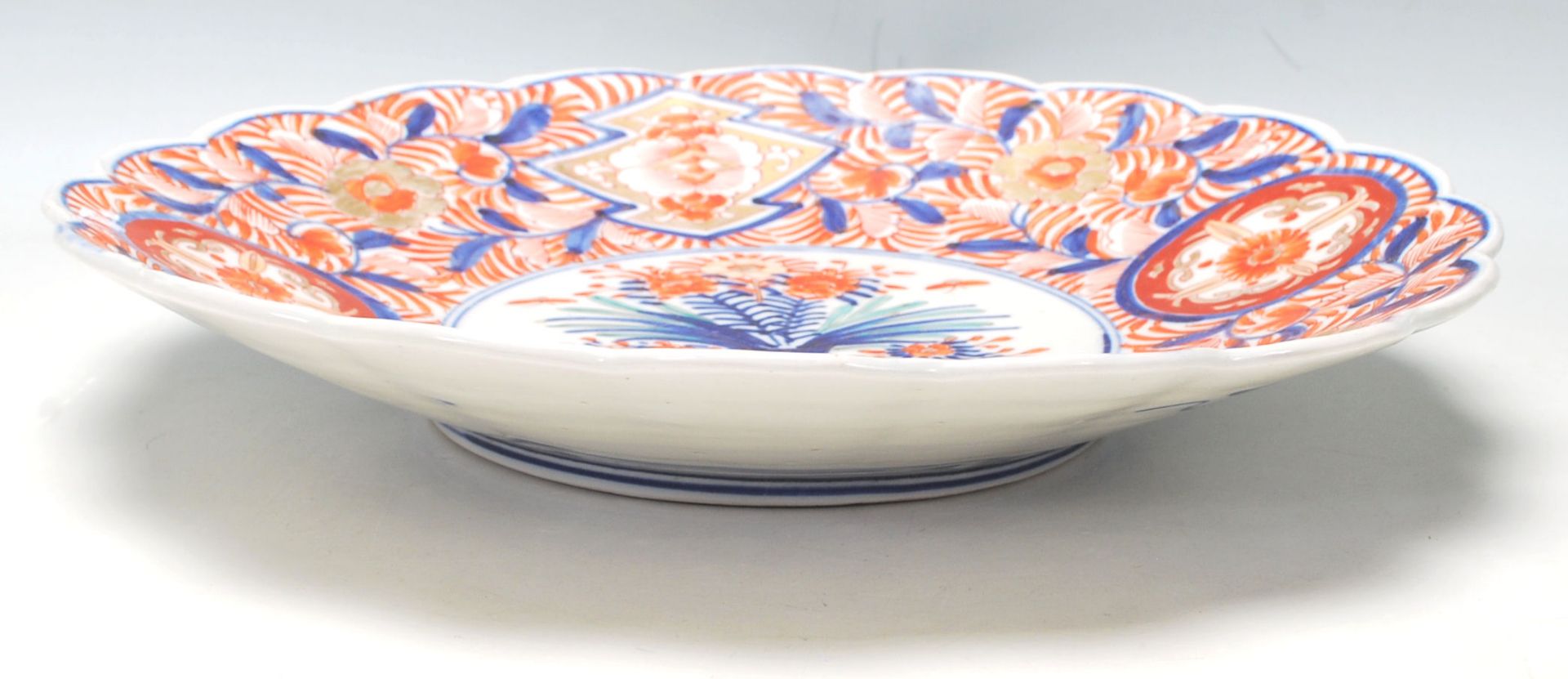 A 19th Century Japanese Imari charger plate with scalloped rim, typical decoration with a vase of - Bild 5 aus 6