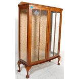 A 20th Century, circa 1940's Queen Anne style walnut china display cabinet vitrine having a