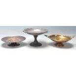 A collection of three tazza dishes, comprising of a tall pewter example with floral decoration to