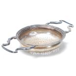 A silver hallmarked 1920's tea strainer having shaped twin handles with pierced holes. Hallmarked