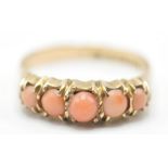 A 19th Century Victorian 9ct gold ring set with five angel skin coral cabochons in prong settings.